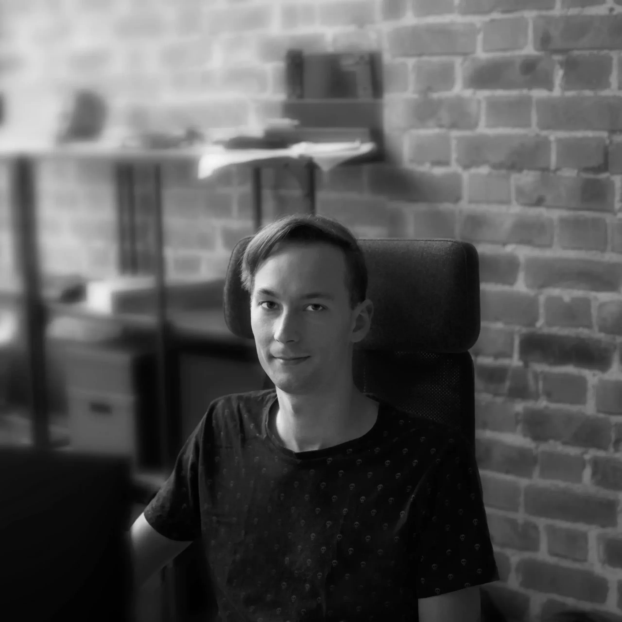 Fotografia osoby pred tehlovou stenou